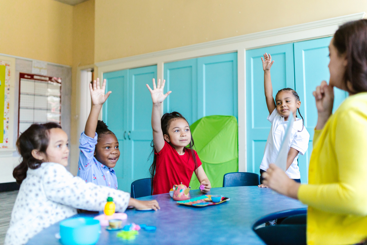 Kids confidently raising their hands in class