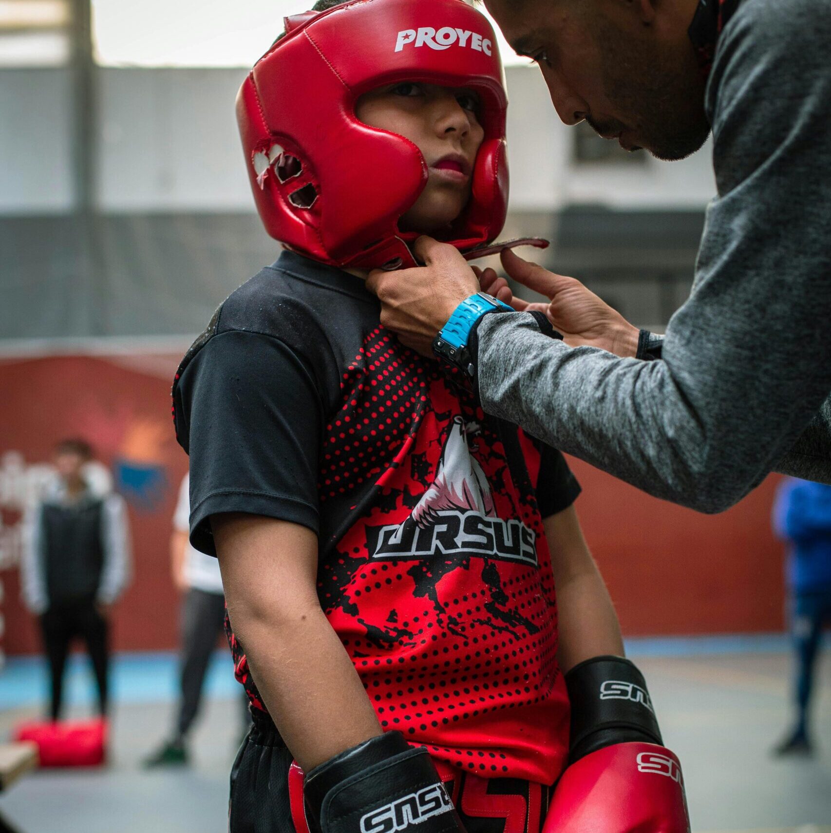 Martial Arts kid getting padded helmet put on before a match